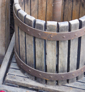 Apple Press with Apples A small apple press with plastic apples next to it.